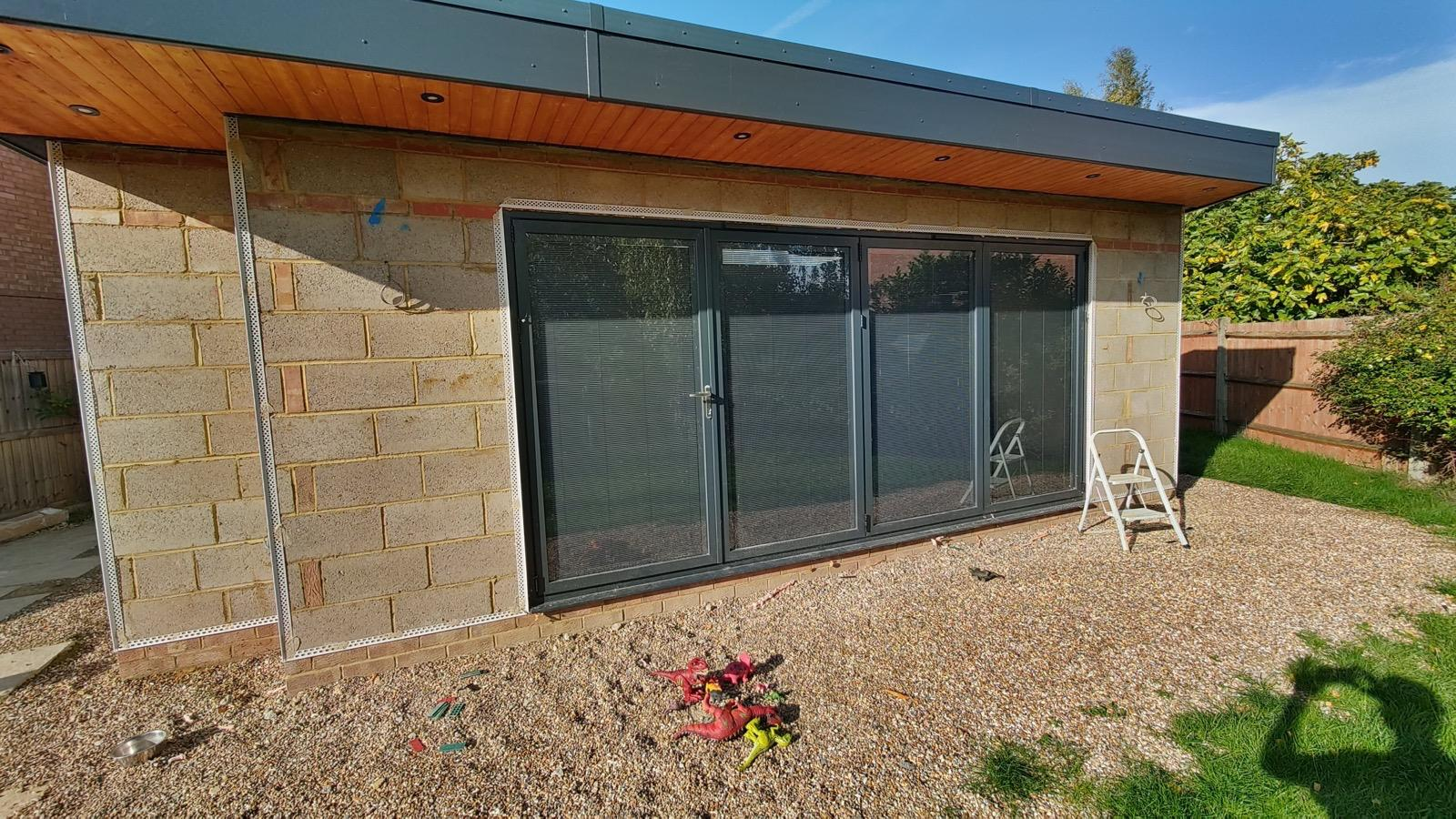 Wide blockwork extension wall with glazed doors and fitted render beads