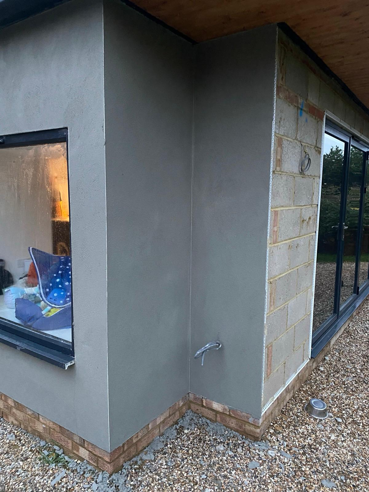 Freshly rendered extension corner next to beaded blockwork