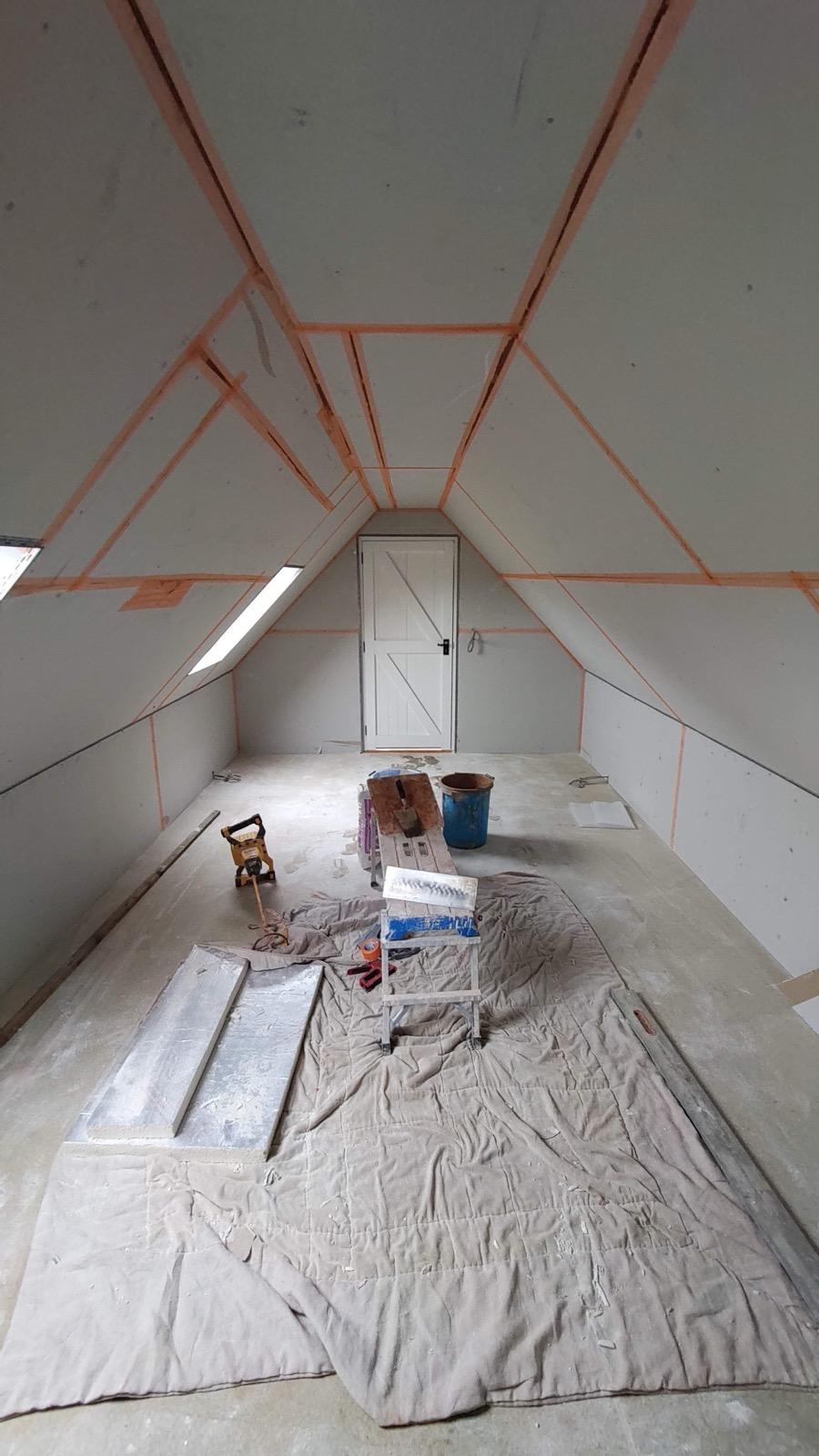 Long loft room plasterboarded and taped with plastering tools laid out