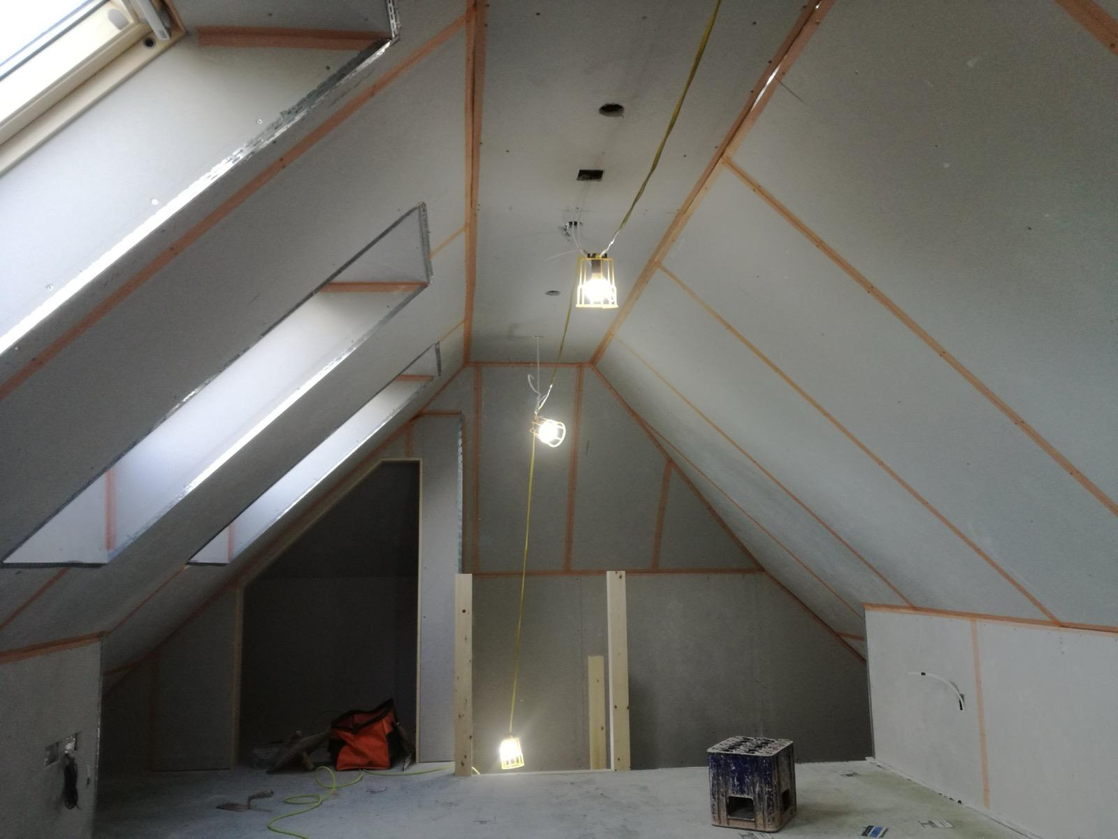 Boarded pitched loft ceiling with roof windows and taped joints