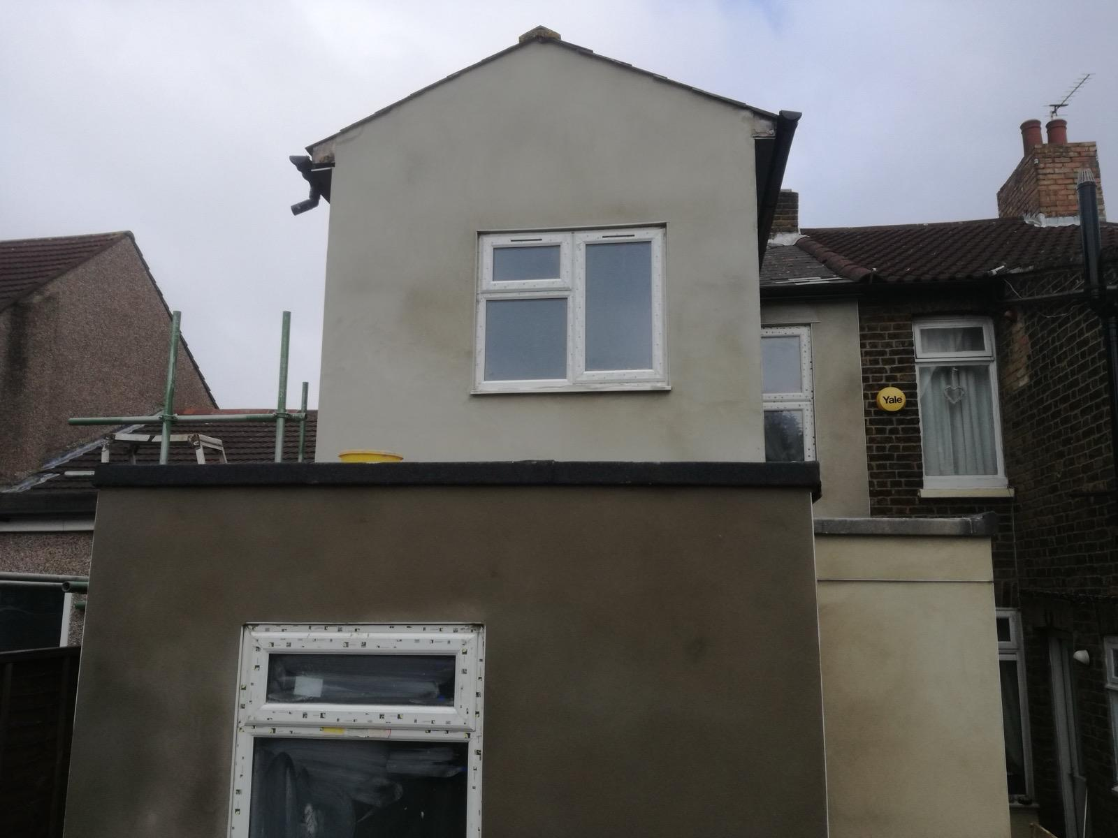 Rear house extension with light and dark rendered exterior walls and white-framed windows