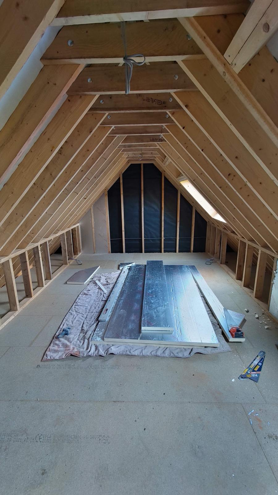 Timber-framed loft interior with roof window before boarding and plastering
