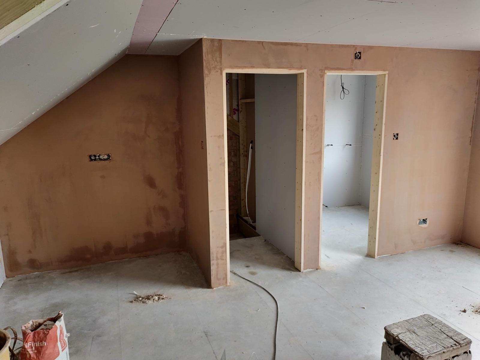 Wet plaster drying on loft walls around two new doorways
