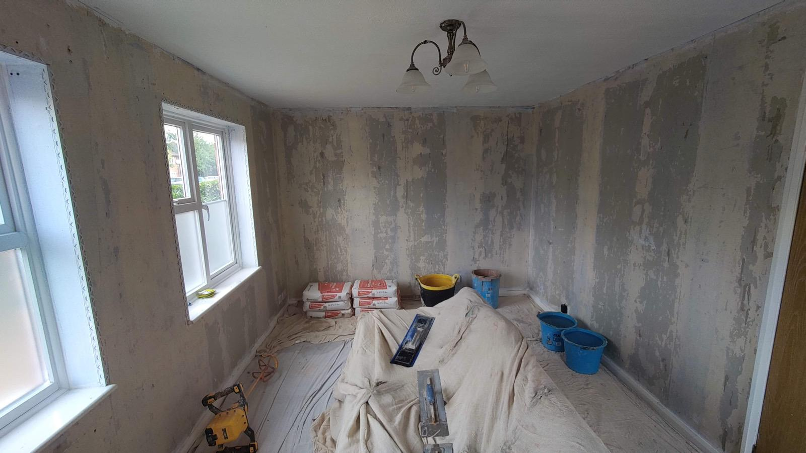 Stripped interior walls prepared for plastering with floors and furniture protected