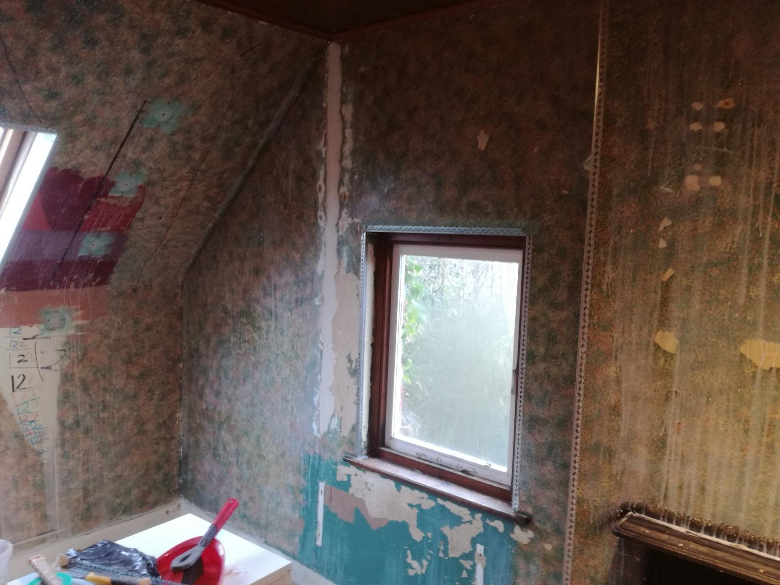 Stripped interior wall around a window with corner beading in place