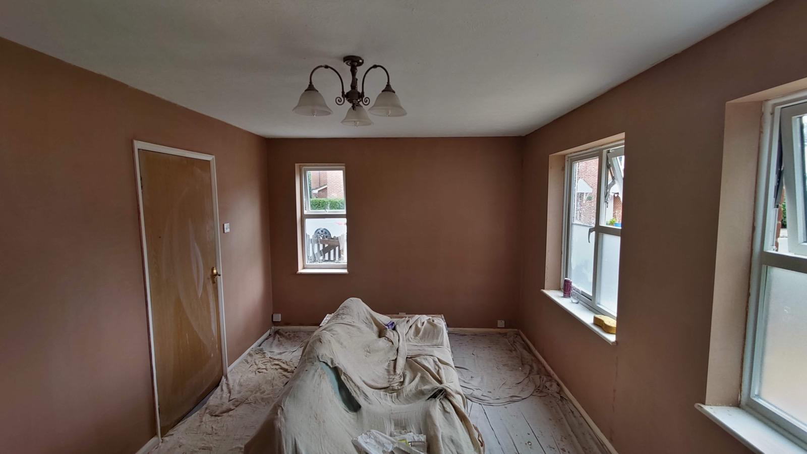 New plaster across a room with three white-framed windows