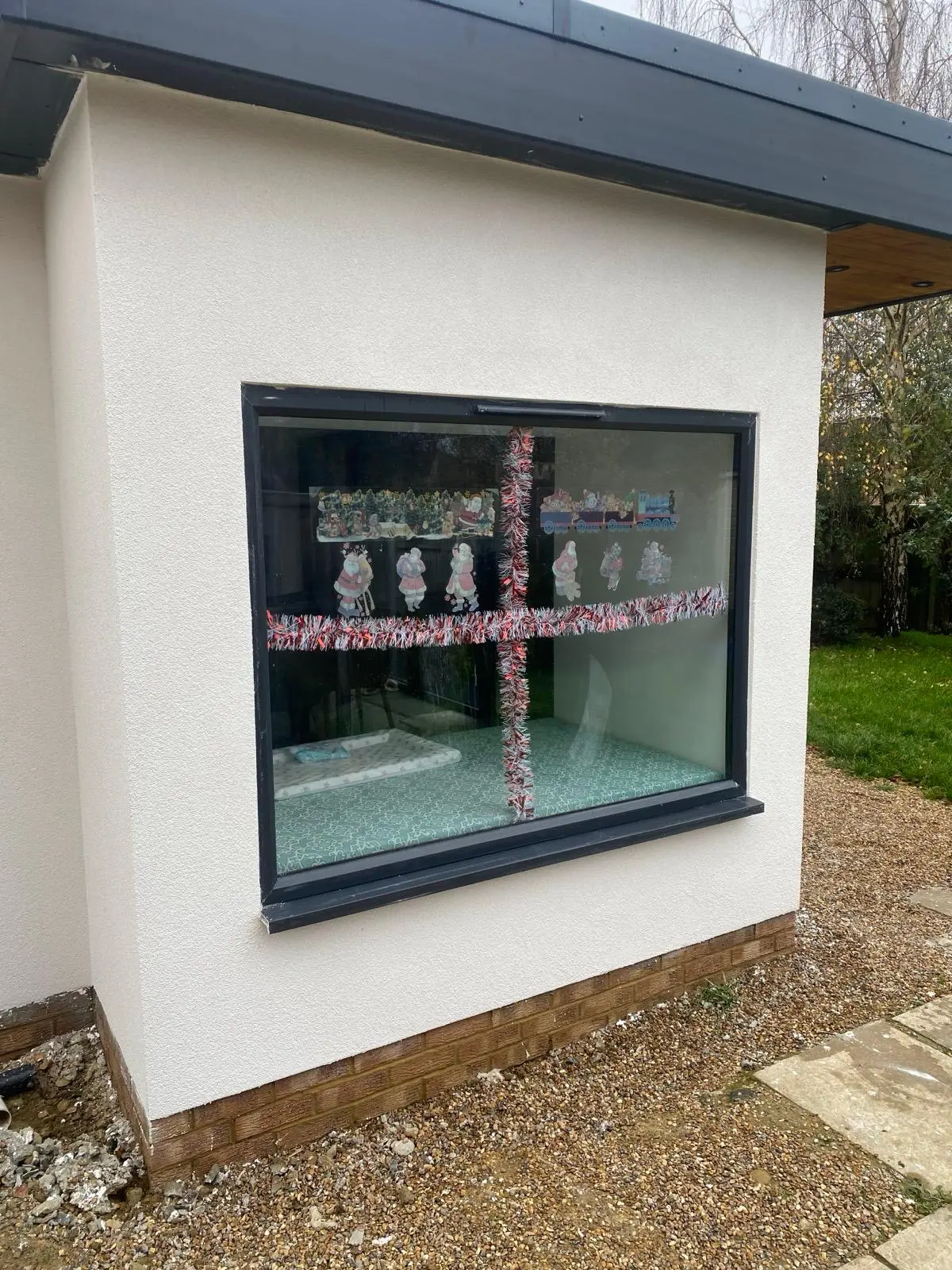 Finished light-coloured render surrounding a large dark-framed window