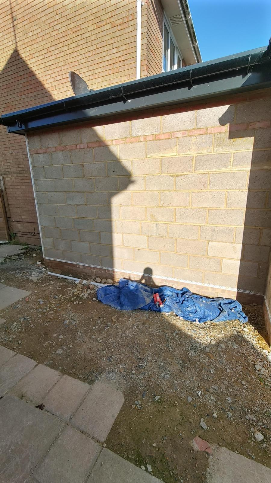 Exterior blockwork wall with render beads fitted beneath the roofline