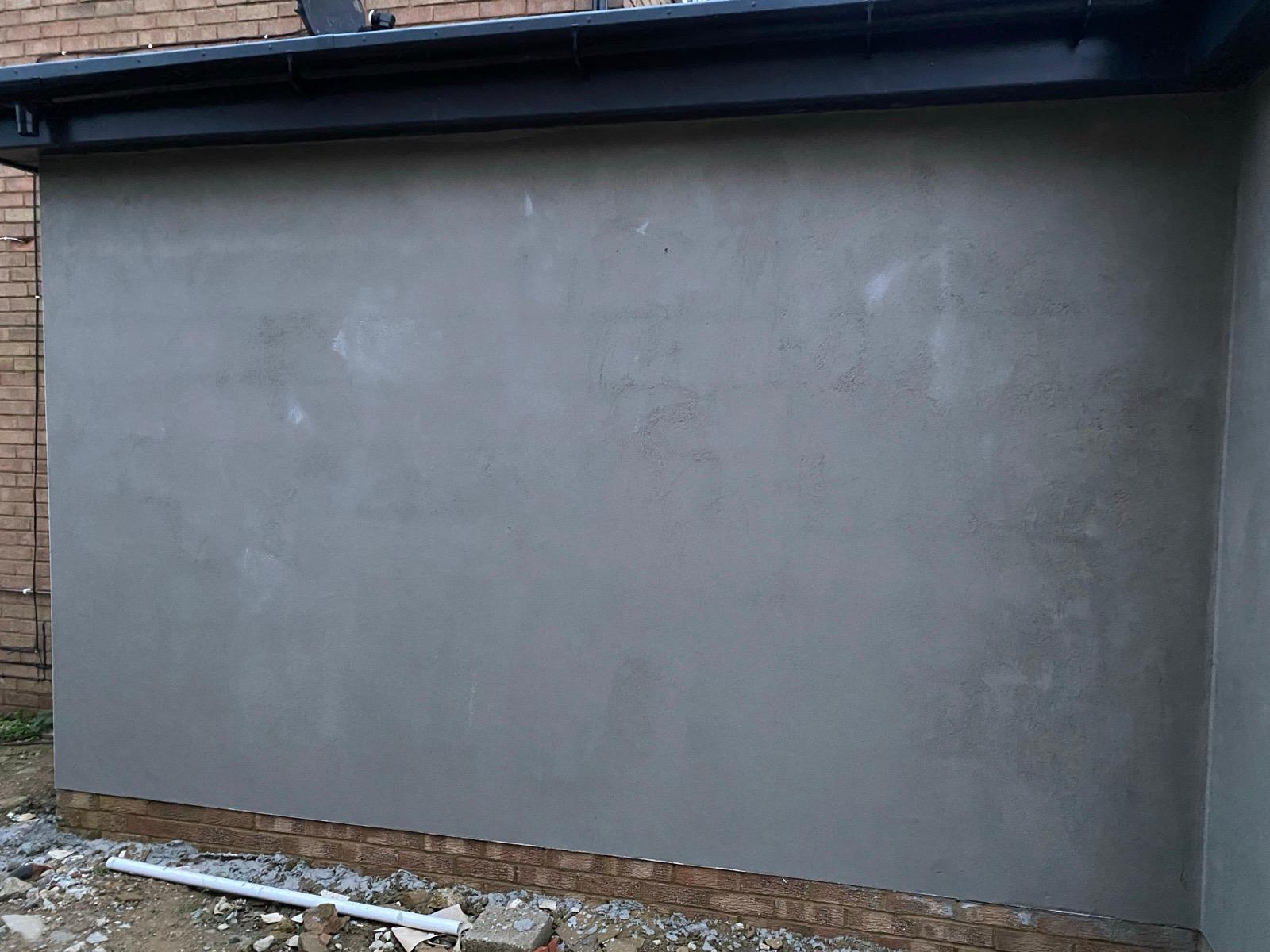 Large freshly rendered grey extension wall