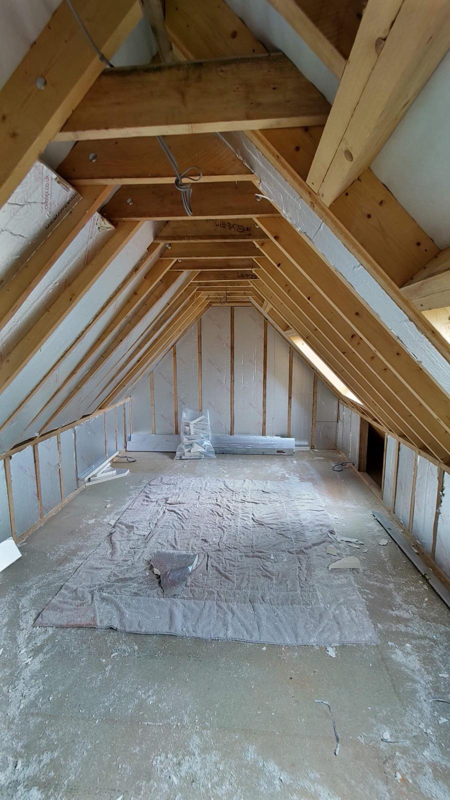 Timber loft framework with insulation fitted between lower wall sections
