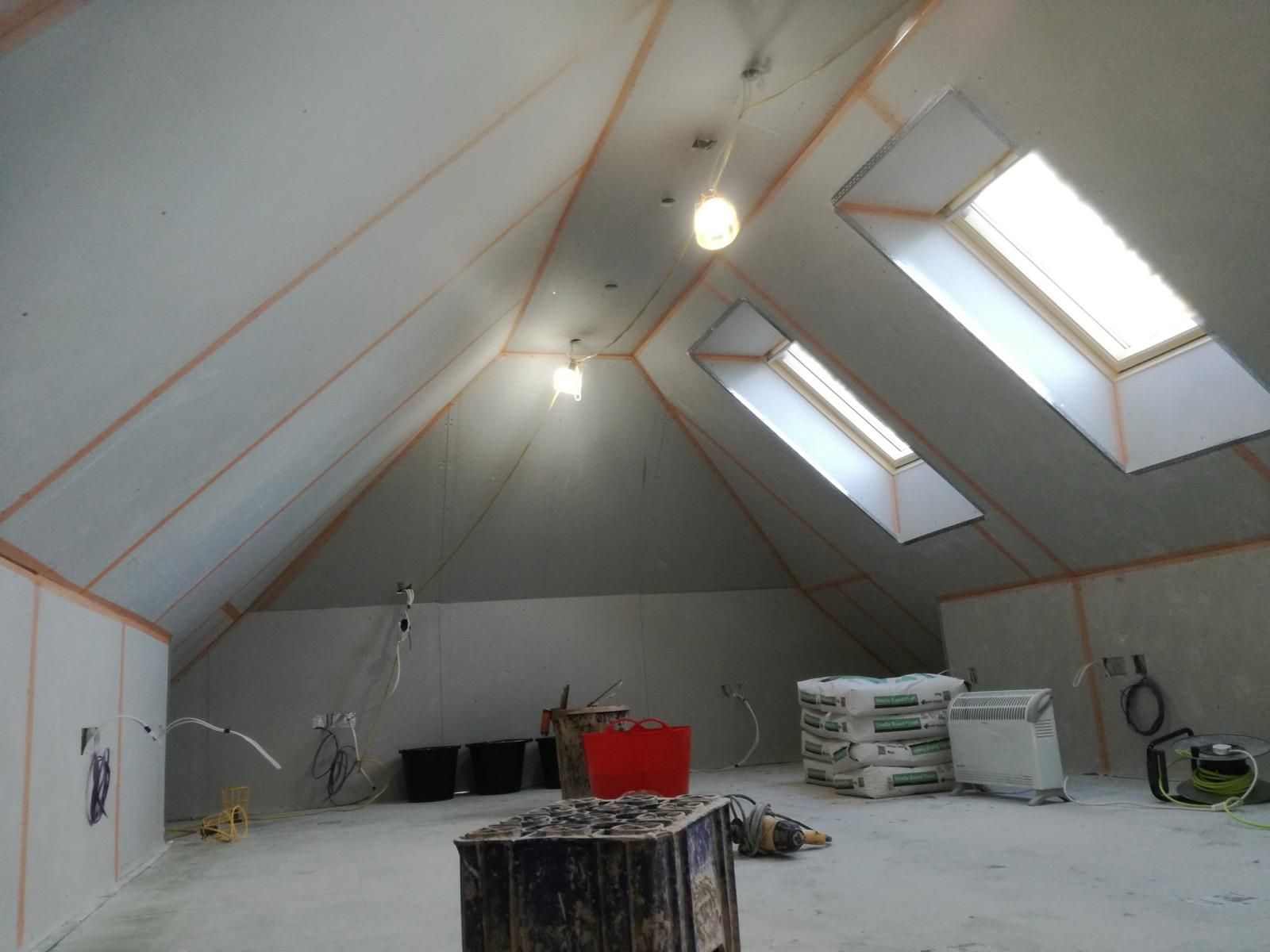 Loft room with boarded sloping ceilings, roof windows and exposed preparation lines