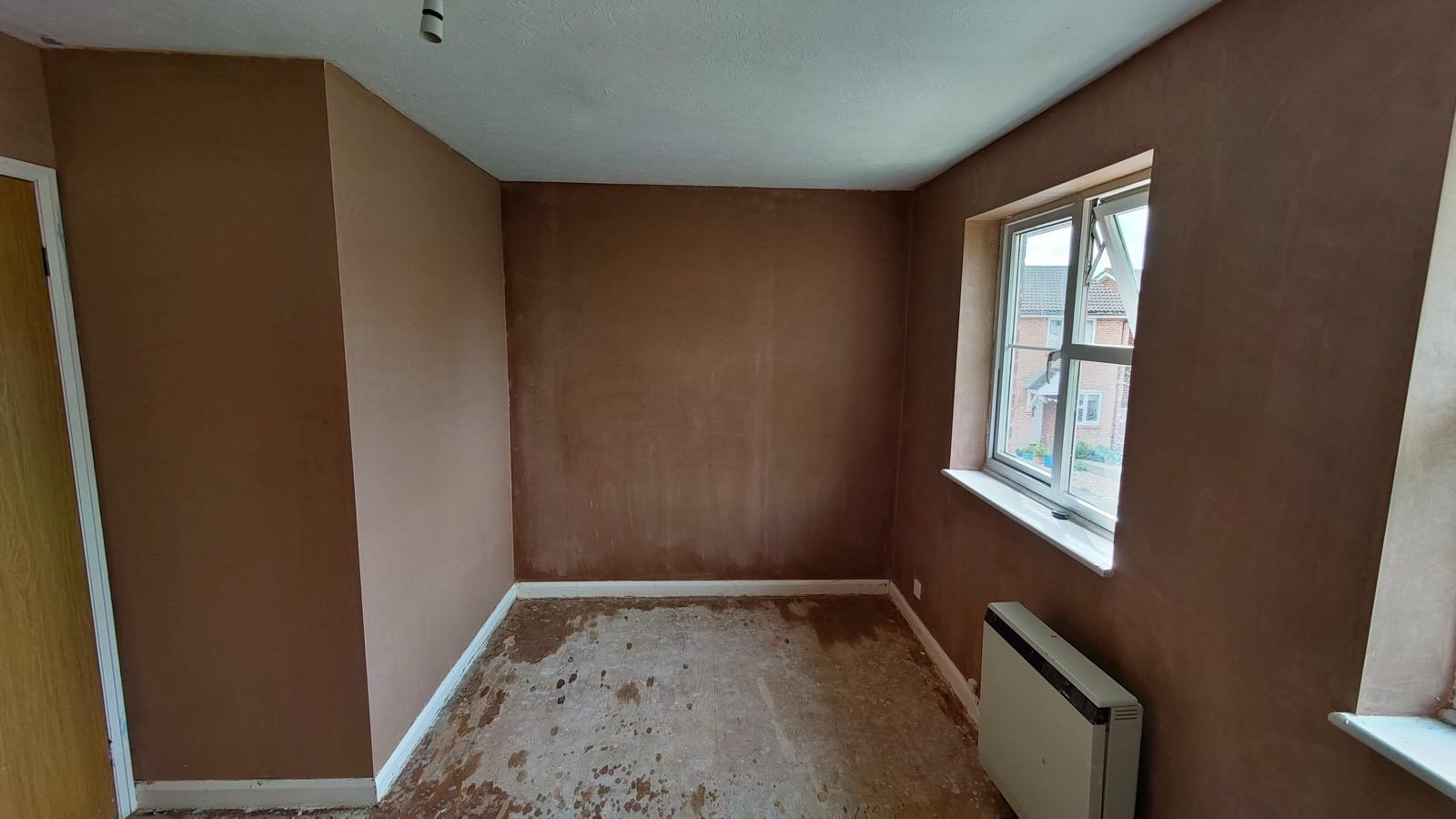 New plaster drying on room walls around a window and wall heater